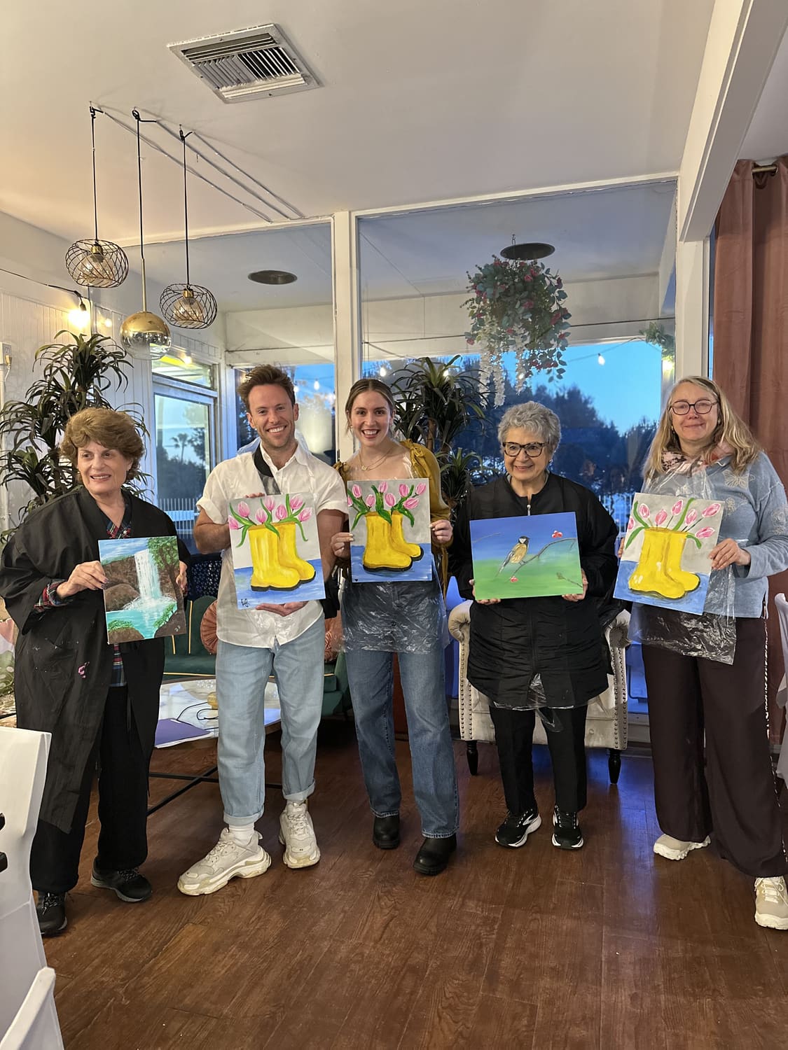 A group holding up the matching paintings they created together