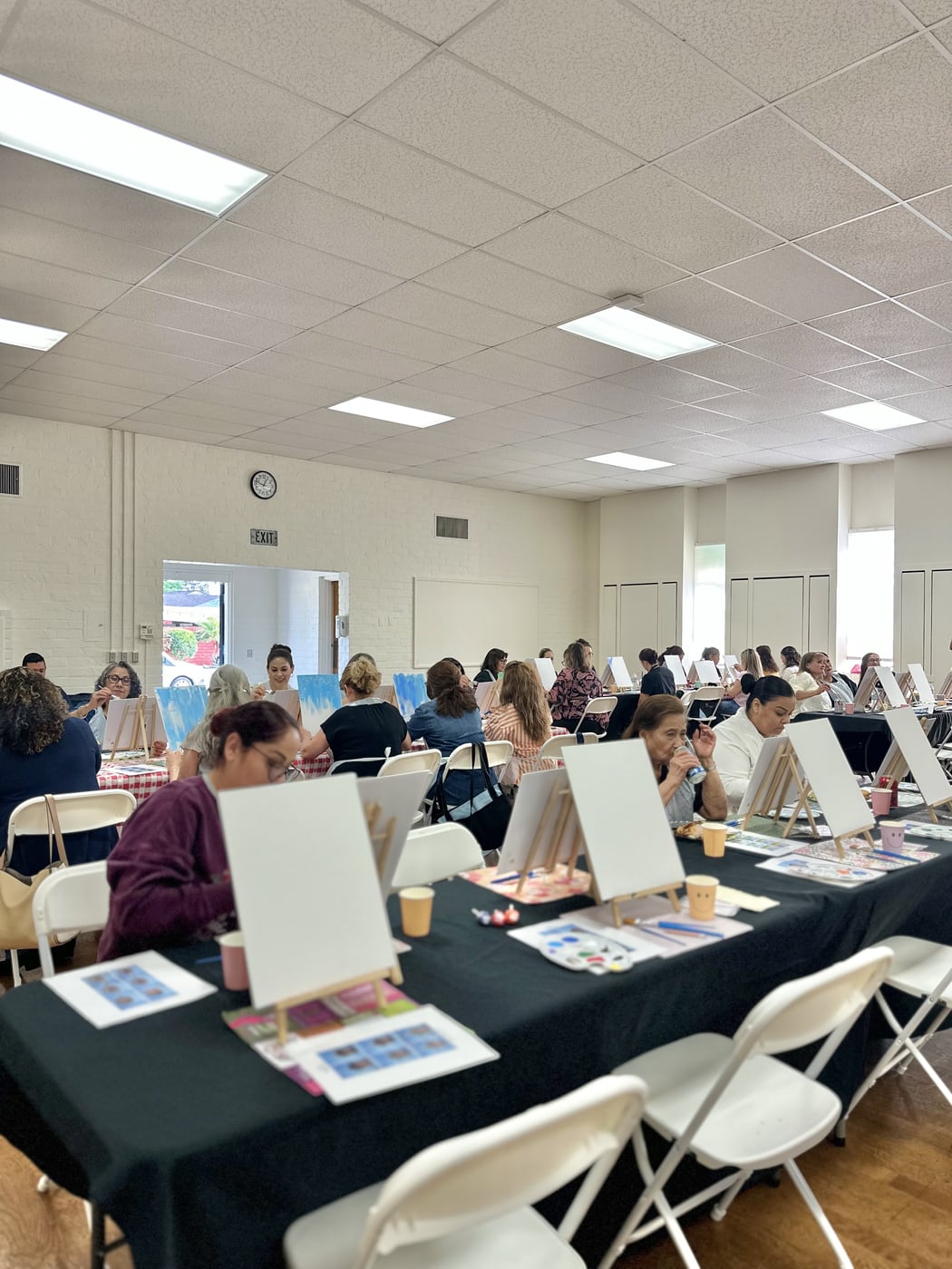 Rows of easels filling a hall for a large-group painting activation