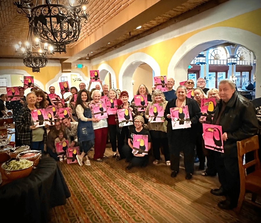 A large group displaying their finished toucan paintings